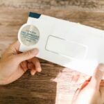 Hands holding a pre-approved offer envelope on a wooden table. Perfect for financial marketing.